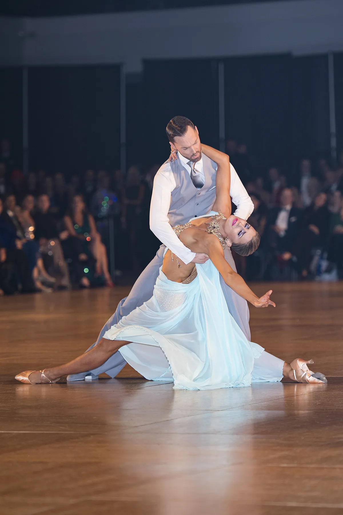 Jaimee falls back into a dip in an ice-blue gown, Travis anchoring the shape from above