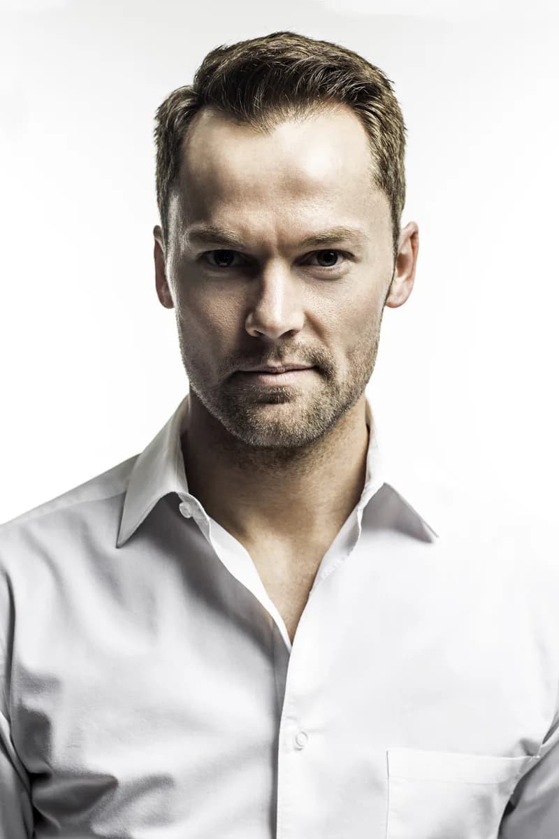 Travis Tuft headshot in a white shirt