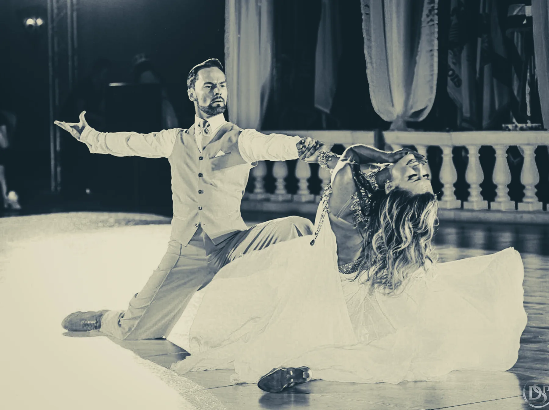 Travis cradles Jaimee in a close dip, her gown spilling across the floor