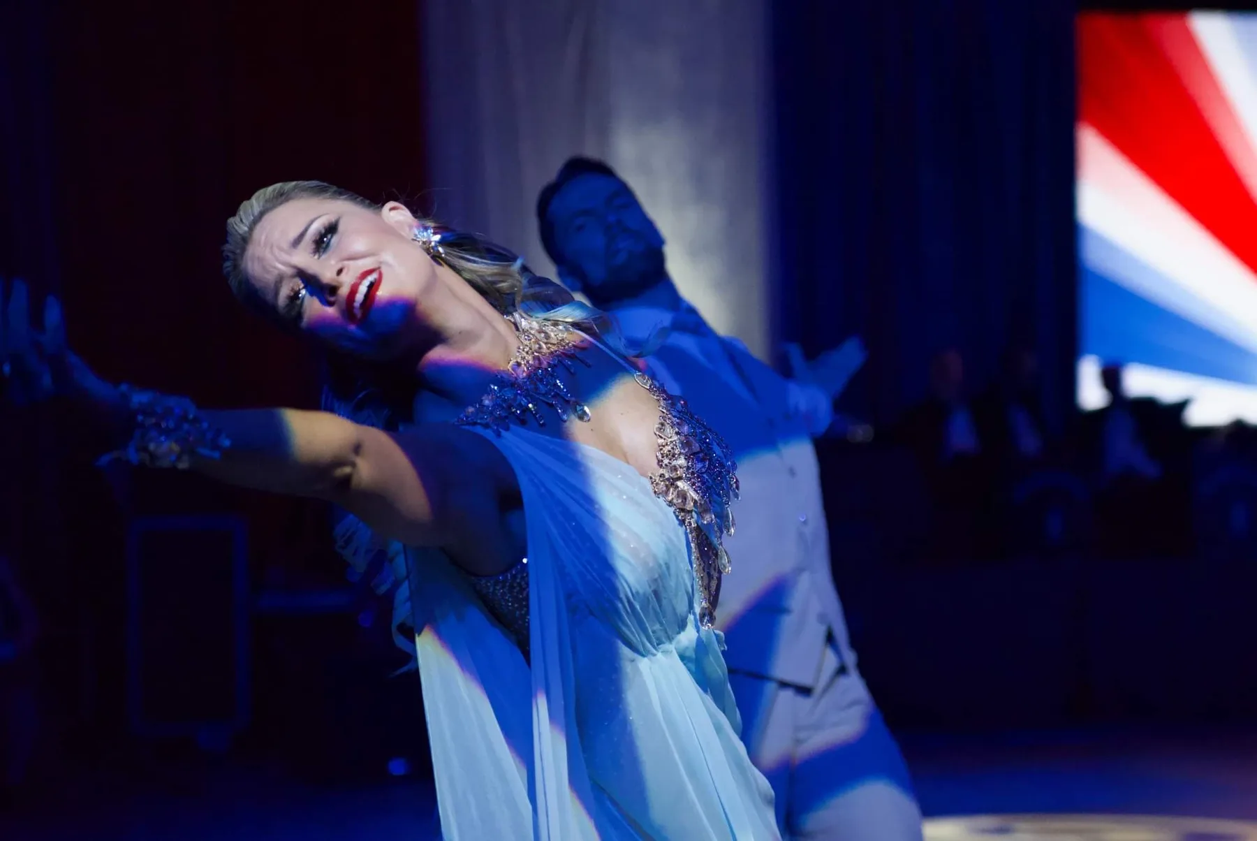 Travis in a sweeping cape draws Jaimee across the floor in the show's character number